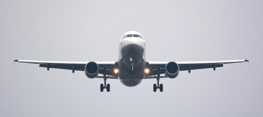 Avião comercial visto de frente em aproximação para pouso, sonho que simboliza chegada de novidades e realizações.