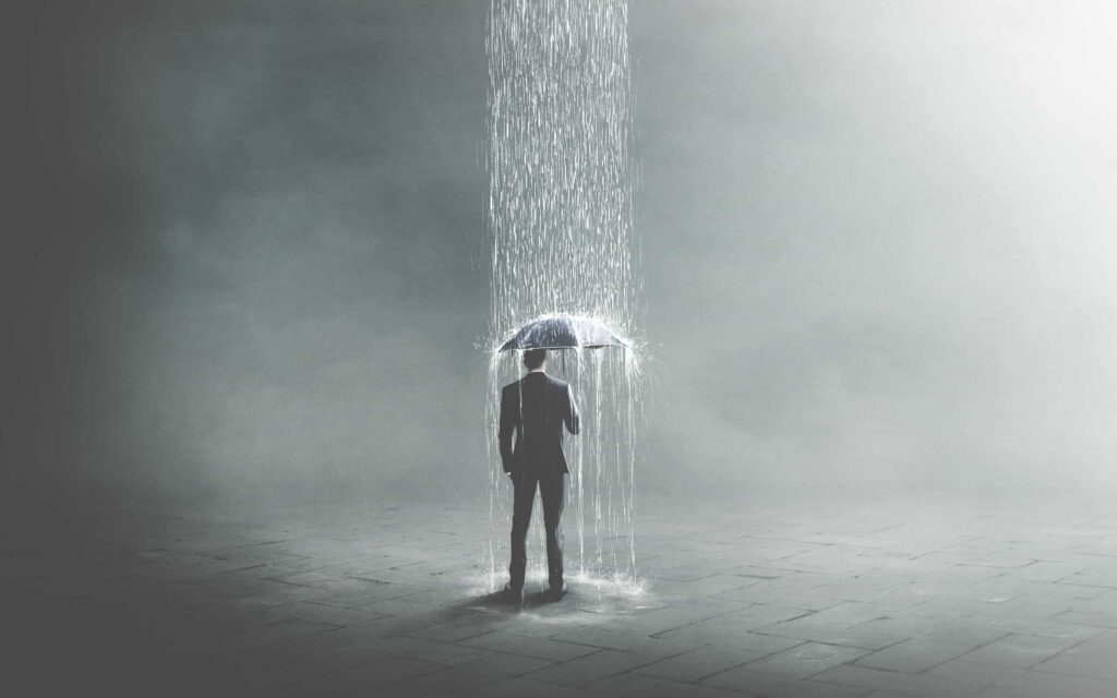 Homem segurando um guarda-chuva sob uma forte chuva em ambiente minimalista, representando sonhar com chuva.