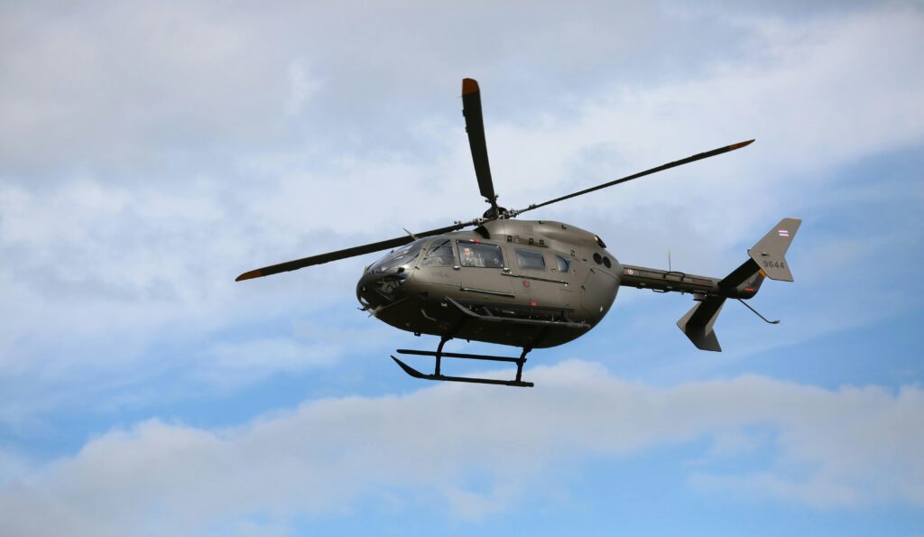 Helicóptero militar voando no céu, associado a sonhos com desafios e superação.