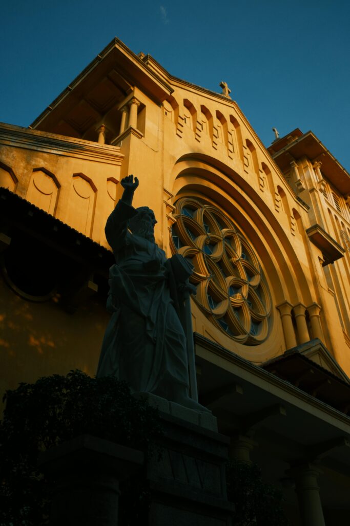 Fachada de igreja com vitrais e estátua religiosa em destaque, representando sonhar com igreja.