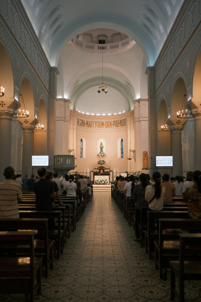 Interior de igreja com fiéis participando de missa, simbolizando sonhar com igreja cheia.