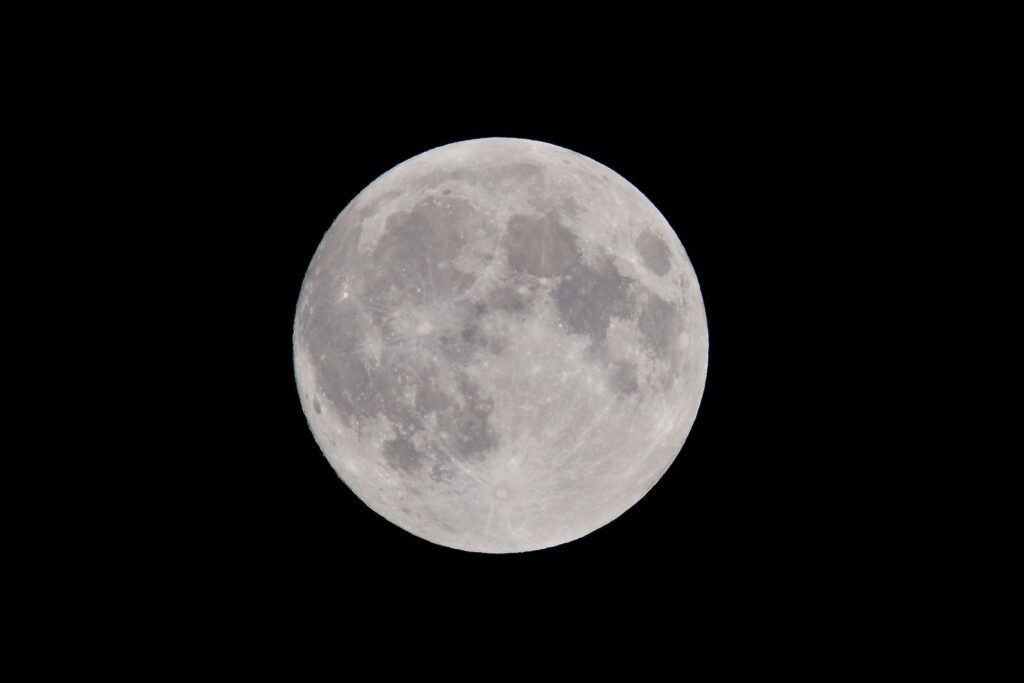 Lua cheia brilhante e clara no céu noturno escuro, simbolizando plenitude, iluminação e revelações nos sonhos.