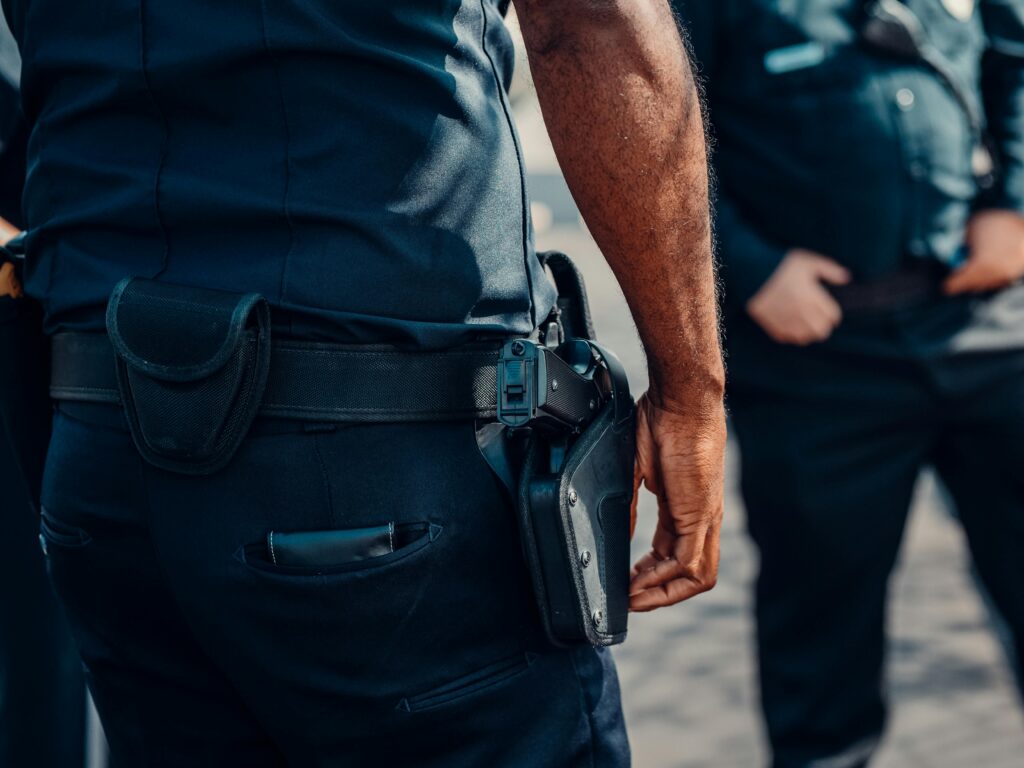 Cintura de policial com arma no coldre, representando força e autoridade.