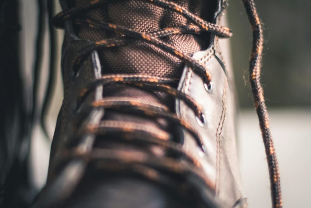 Close-up de bota marrom com cadarços, representando segurança e firmeza em sonhos.