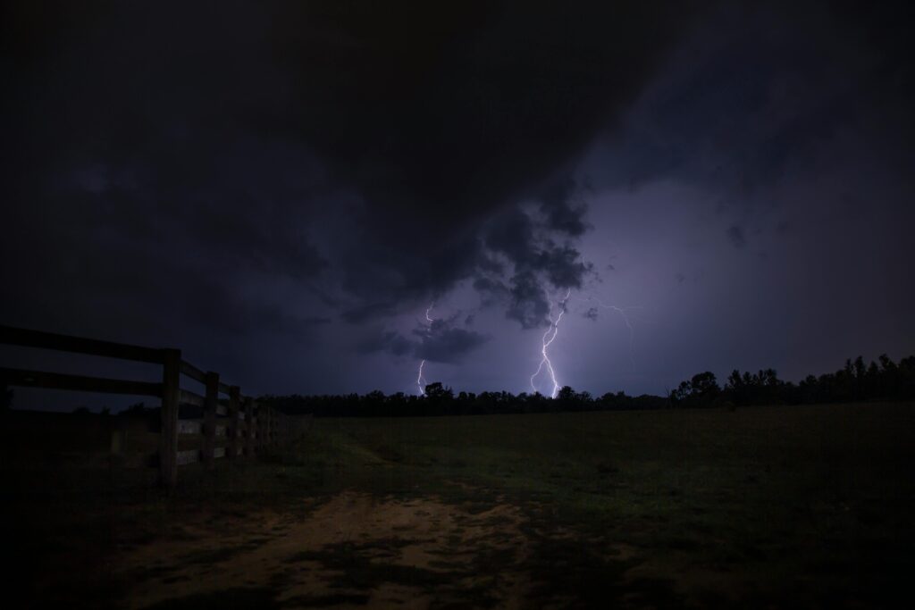 Raios no céu escuro durante tempestade em campo aberto.