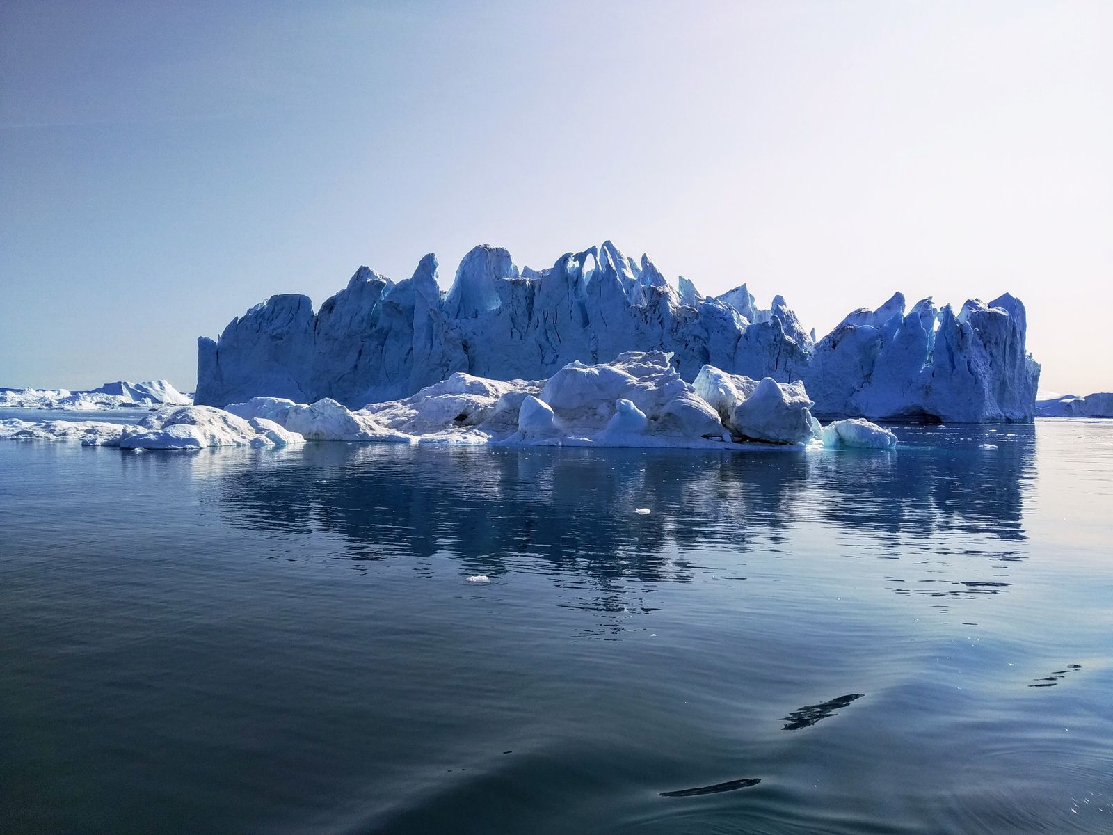 Imagem vertical de um iceberg visto de baixo d’água, mostrando a parte oculta gigante sob a superfície – metáfora do inconsciente