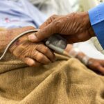 Mãos dadas ao lado de cama de hospital, sonho com mãe doente