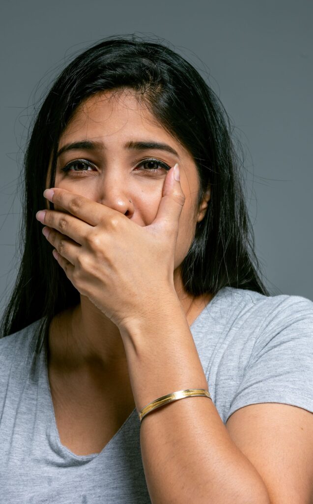 Mulher com a mão sobre a boca, sonho que não consegue falar